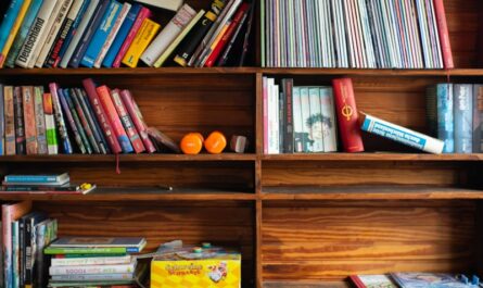 A bookshelf filled with lots of books on top of a wooden floor
